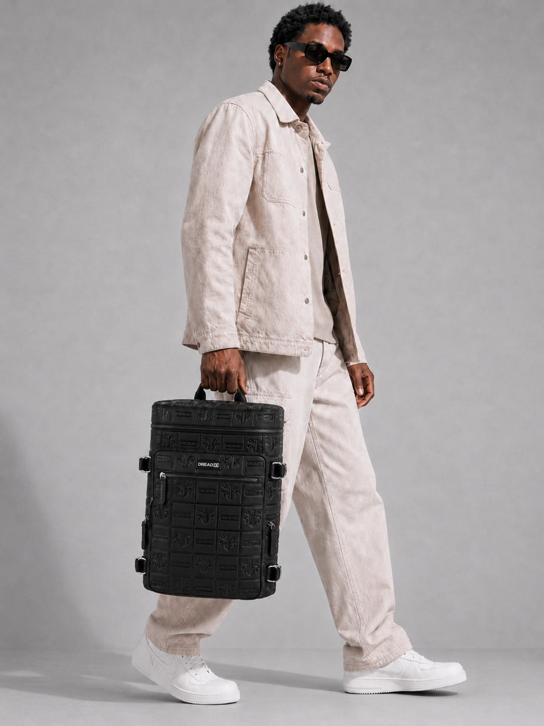 Model wearing the black DREAD IX backpack in a clean studio look